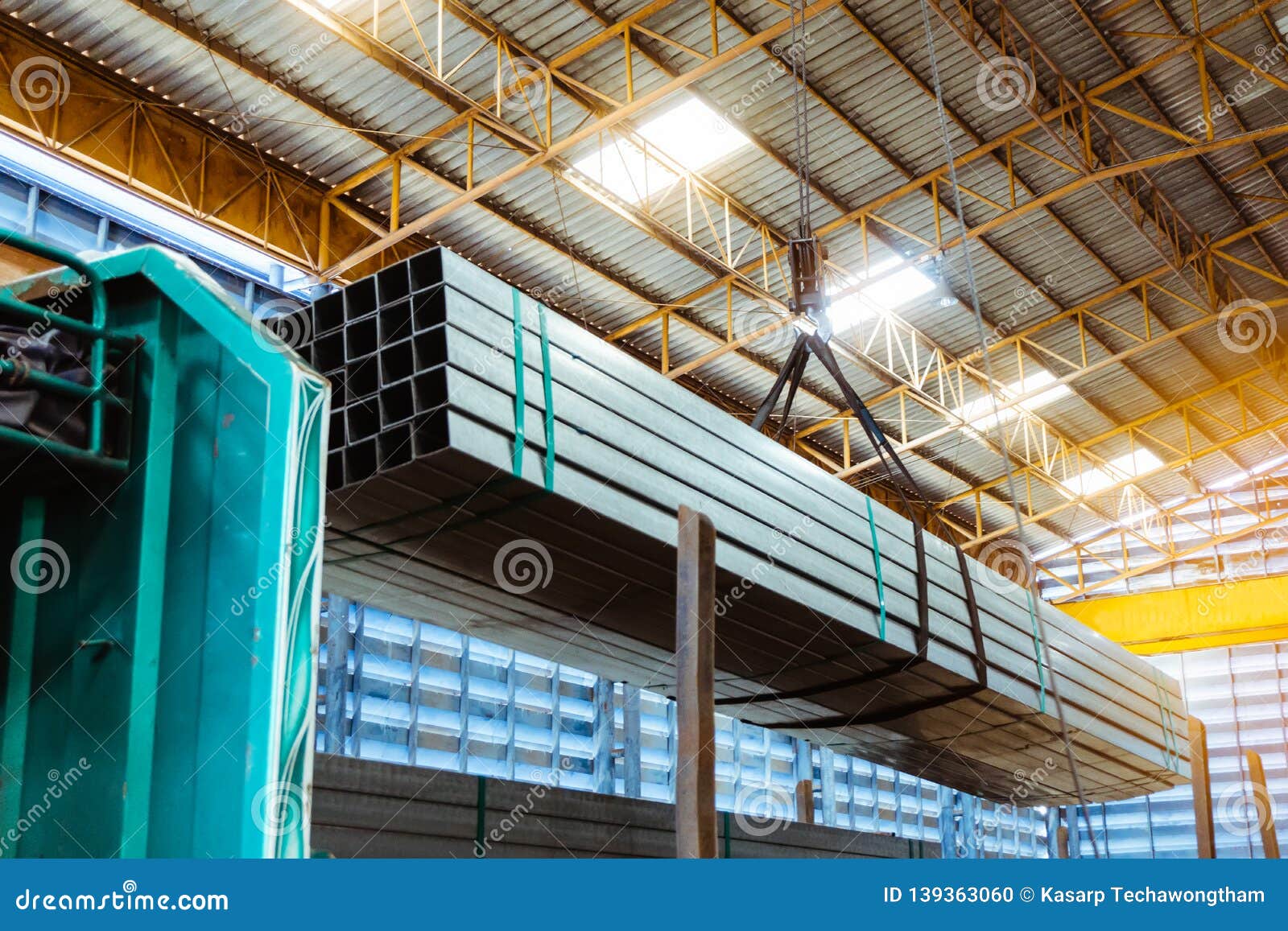 electric cable hoist , heavy hoist iron hook lifting of steel pipes bunch and place on a truck at warehouse