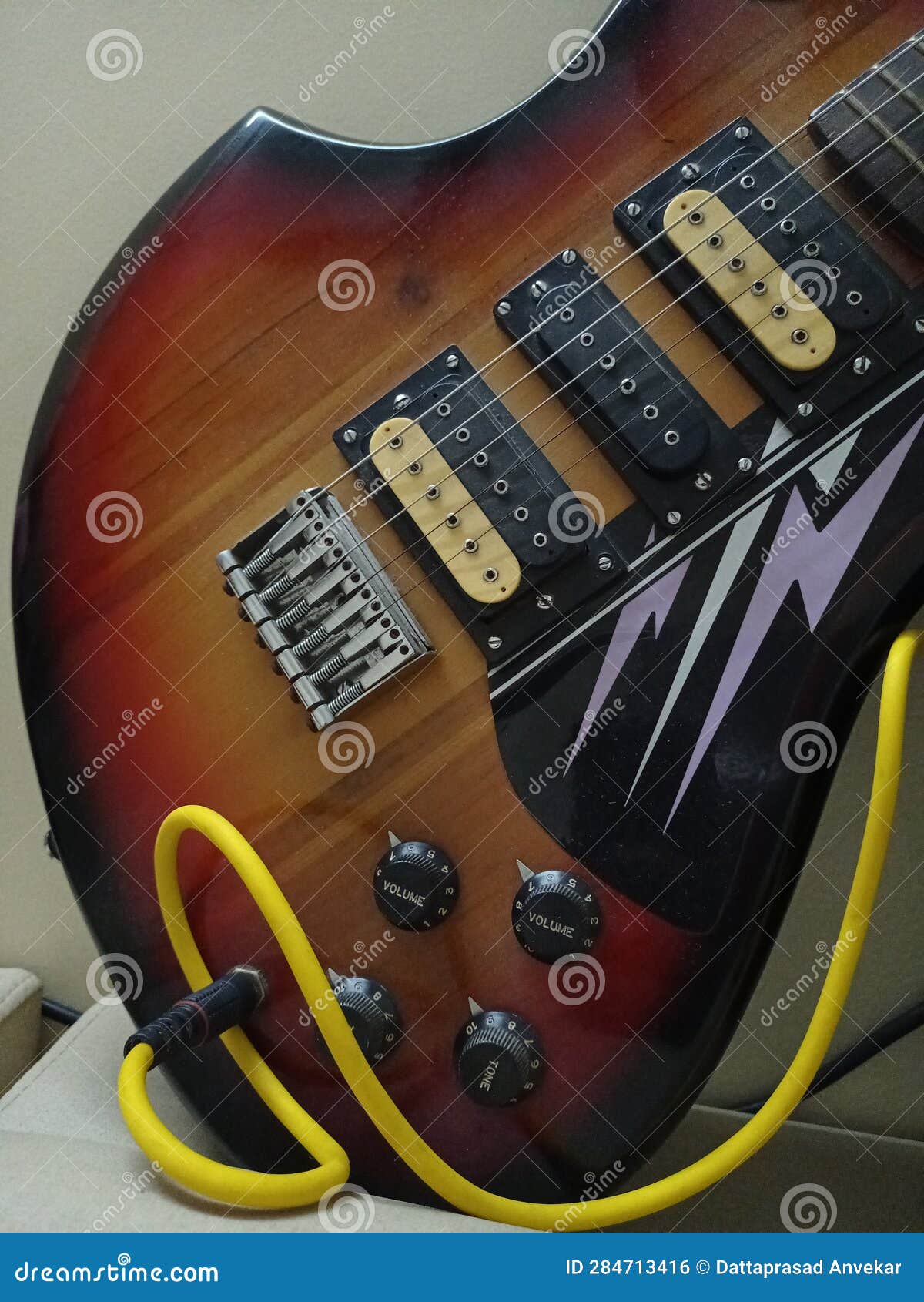 Electric Guitar with Yellow Colour Cable Closeup View Stock Photo