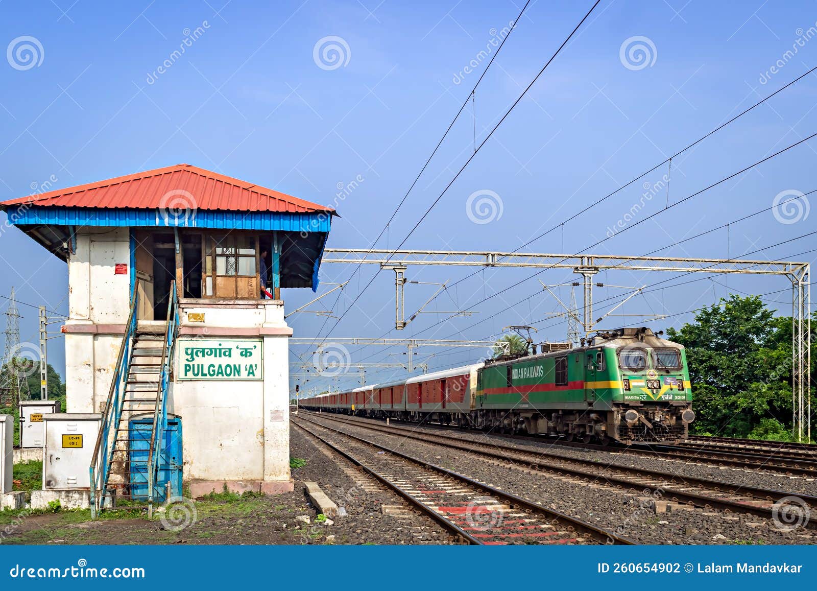 electric loco powered parcel train , passing past the old signal cabin at pulgaon