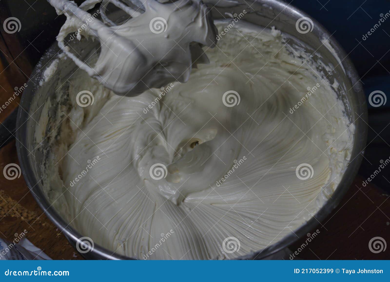 Beating a white cream with a mixer in a metal bowl. Whipped cream. Cream  for the cake Stock Photo - Alamy