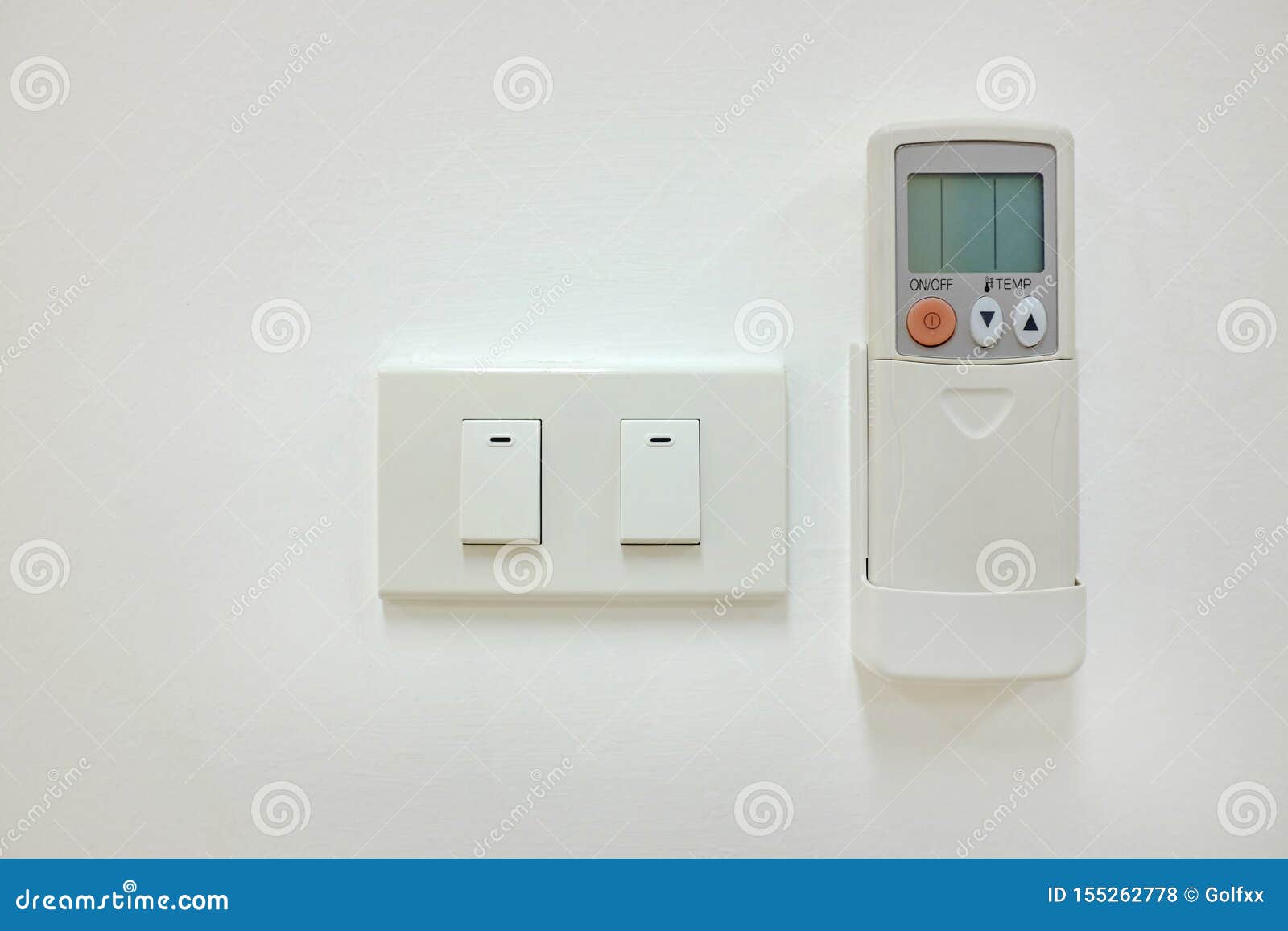 Electric Switch and Air Conditioner Remote Control on the White Wall