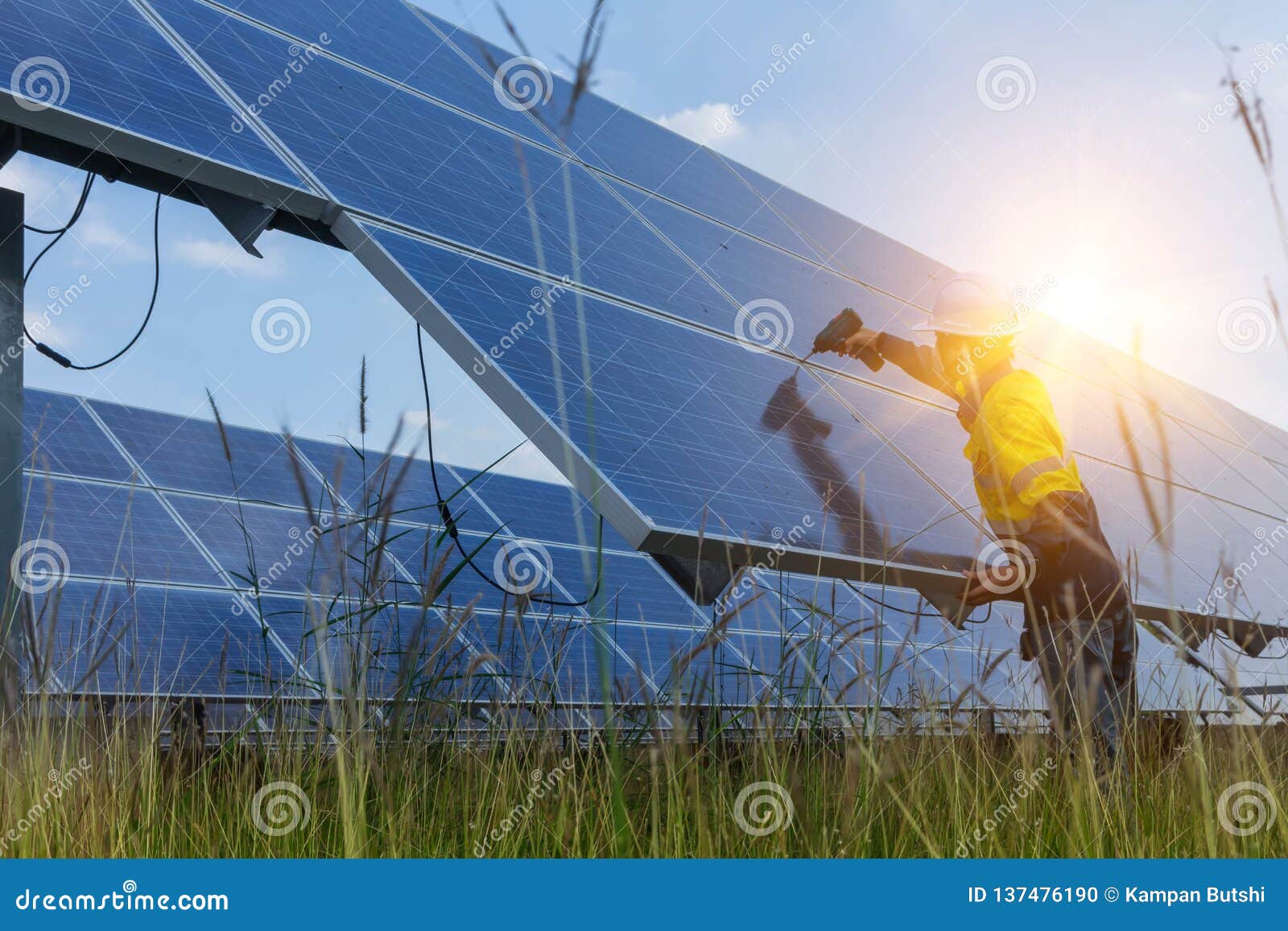 electrical and instrument technician use battery drill to maintenance electric system at solar panel field
