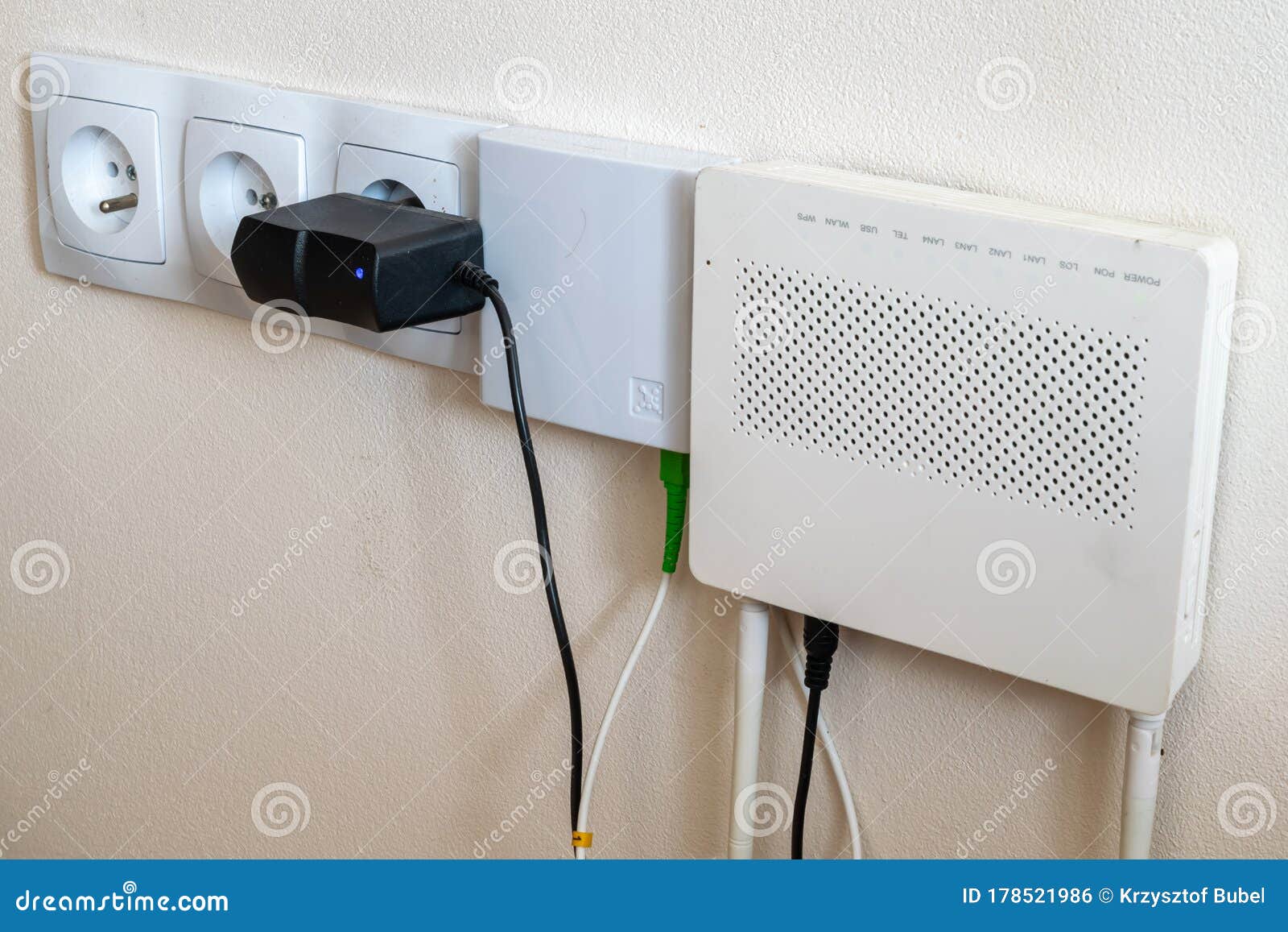 electrical outlets and internet modem on a cream wall background