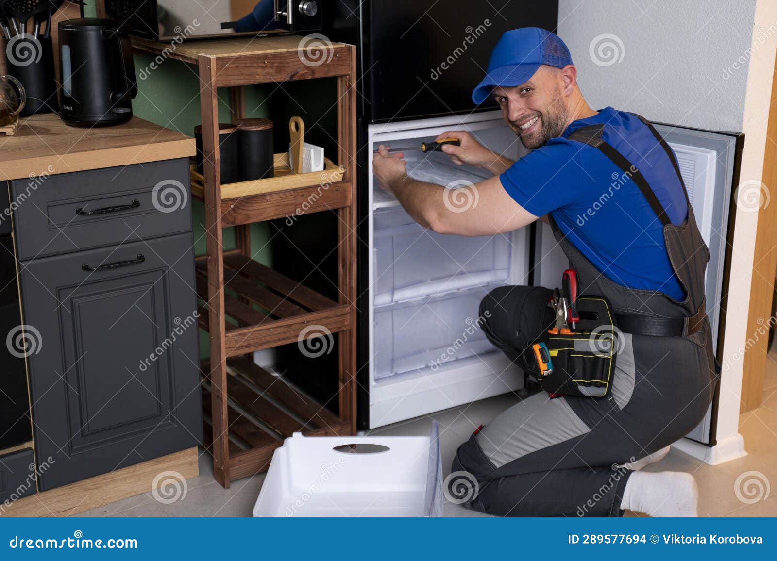 An Electrical Technician Working on the Repair of a Refrigerator or