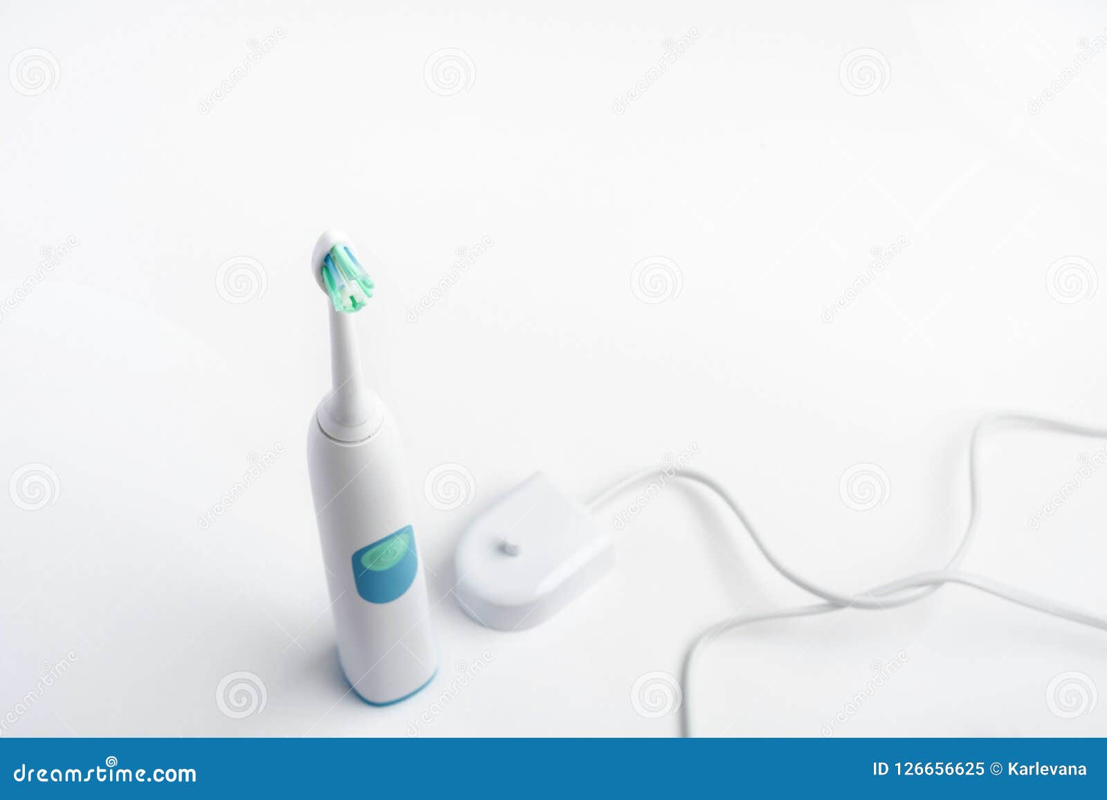electrical toothbrush with battery charger for higiene of mouth cavity on white background