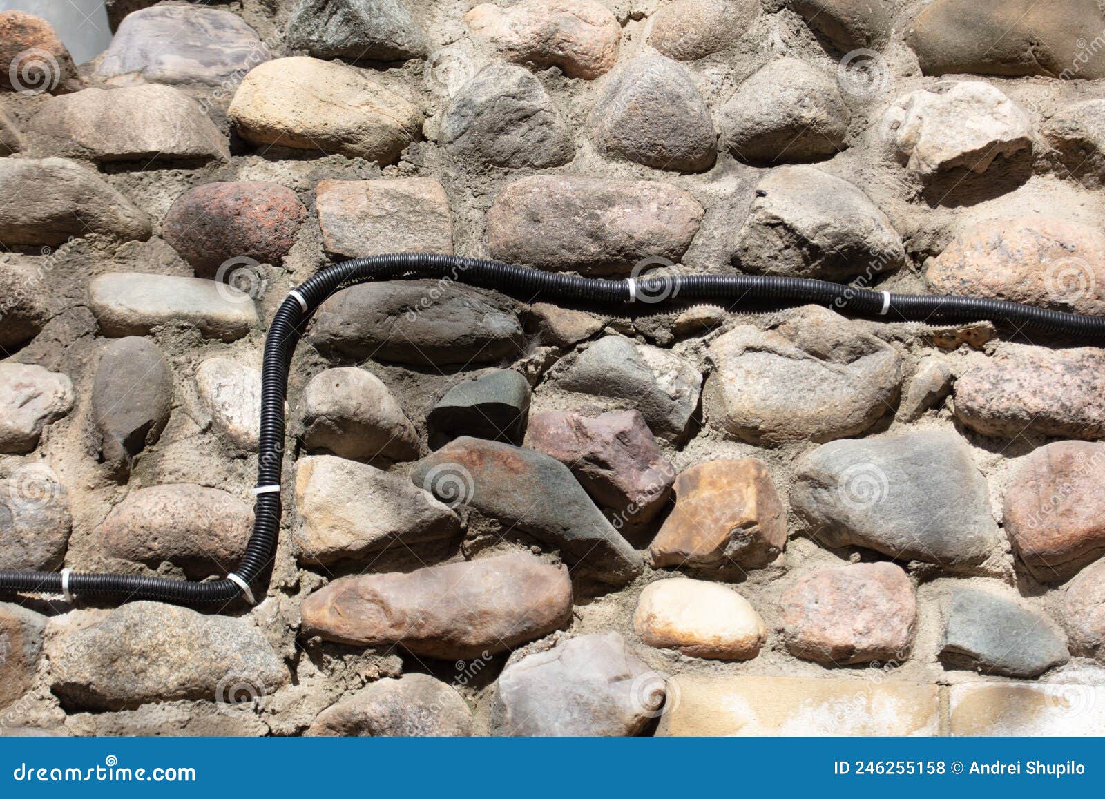 Electrical Wiring on the Wall of Stone Bricks. Stock Photo Image of