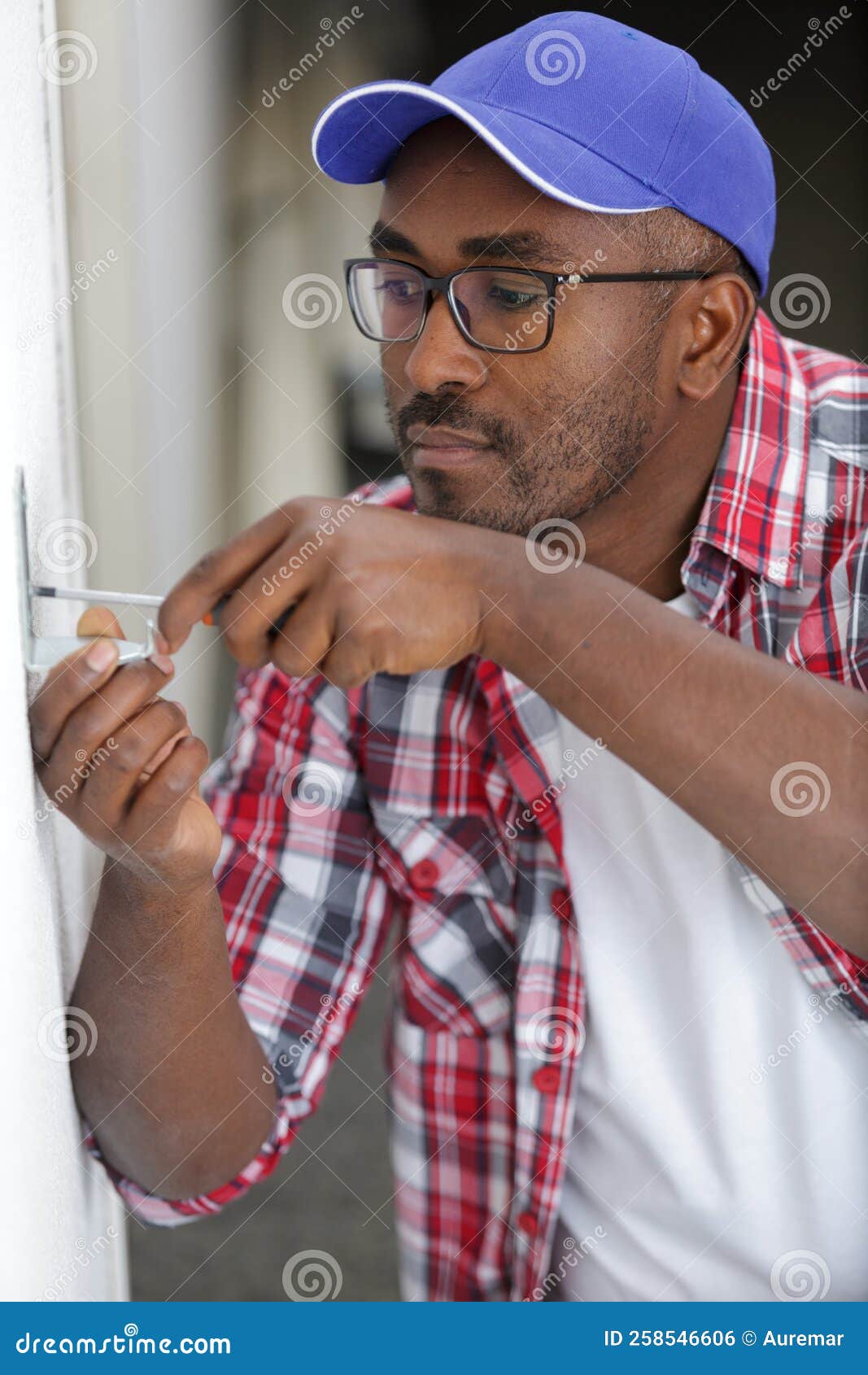 Electrician Checking Voltage Level in Wall Socket Cables Stock Photo