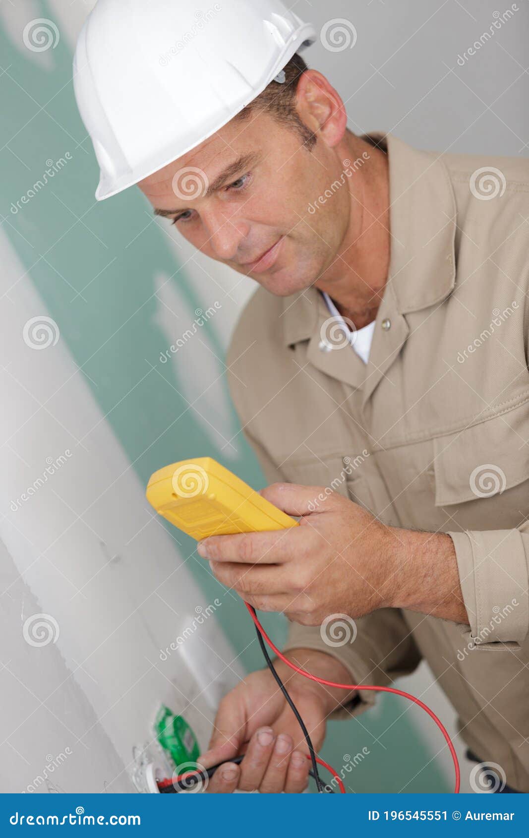 Electrician Checking Voltage in Partially Installed Electrical Wall