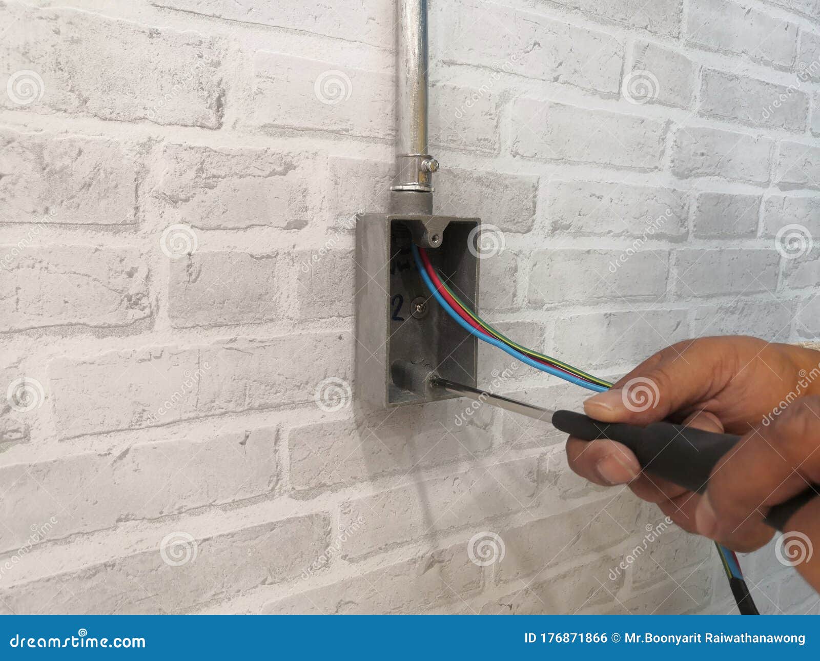 Electrician Installing F.S. BOX for Electrical System Work on Gray