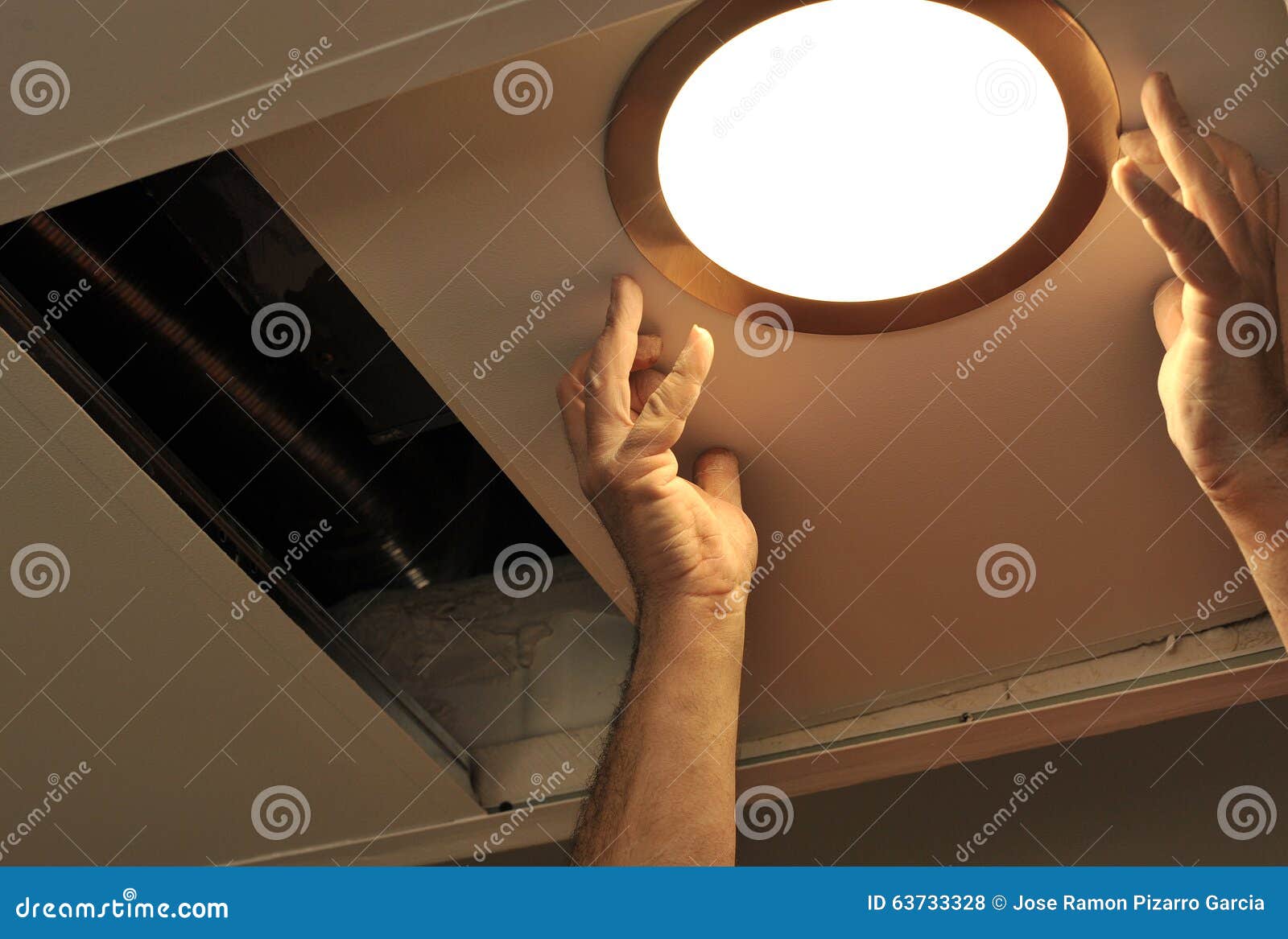 Electrician Installing a Spotlight in the Kitchen Ceiling Stock Photo