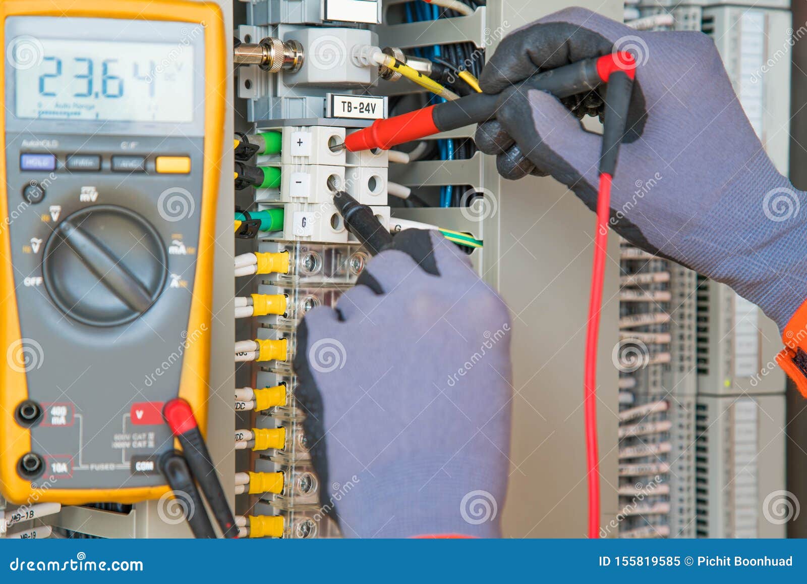 electrician and instrument worker wearing safety gloves measuring voltage and checking electric circuit by using digital meter