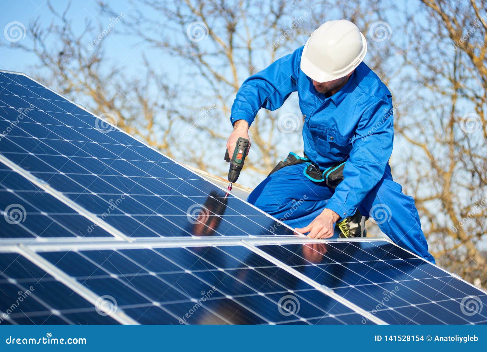 electrician mounting solar panel on roof of modern house