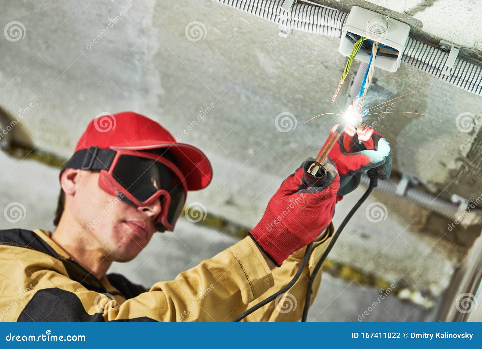 Electrician Service. Installer Works with Cable in Junction Box Stock
