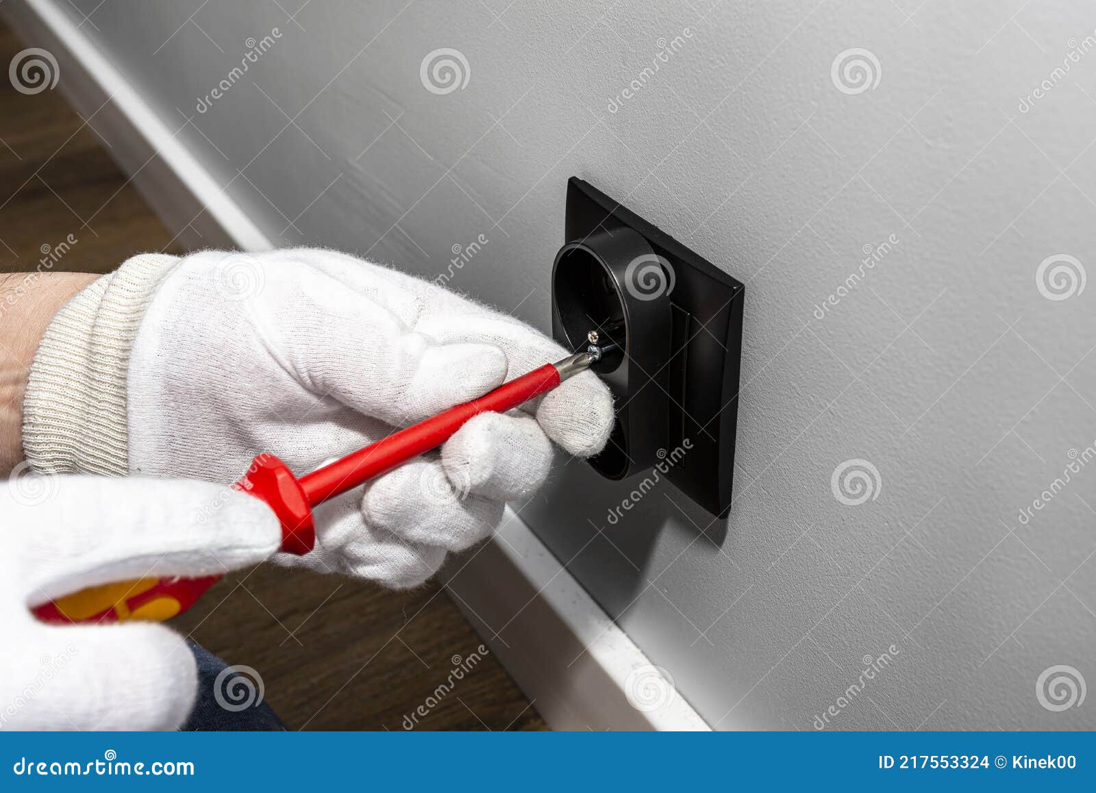 An Electrician Uses a Red Screwdriver To a Black Double Grounded