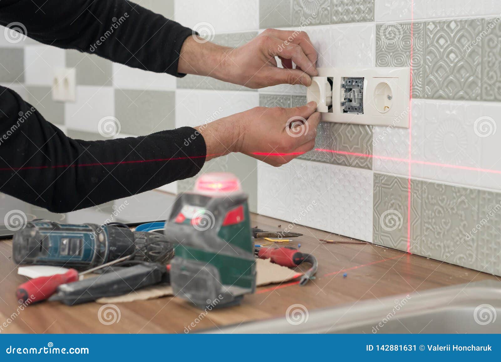 Electrician Using Infrared Laser Level To Install Electrical Outlets