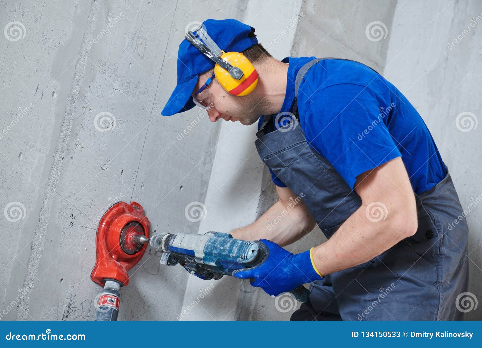 Electrician at Work. Boring Hole for Electric Outlet by Power Tool
