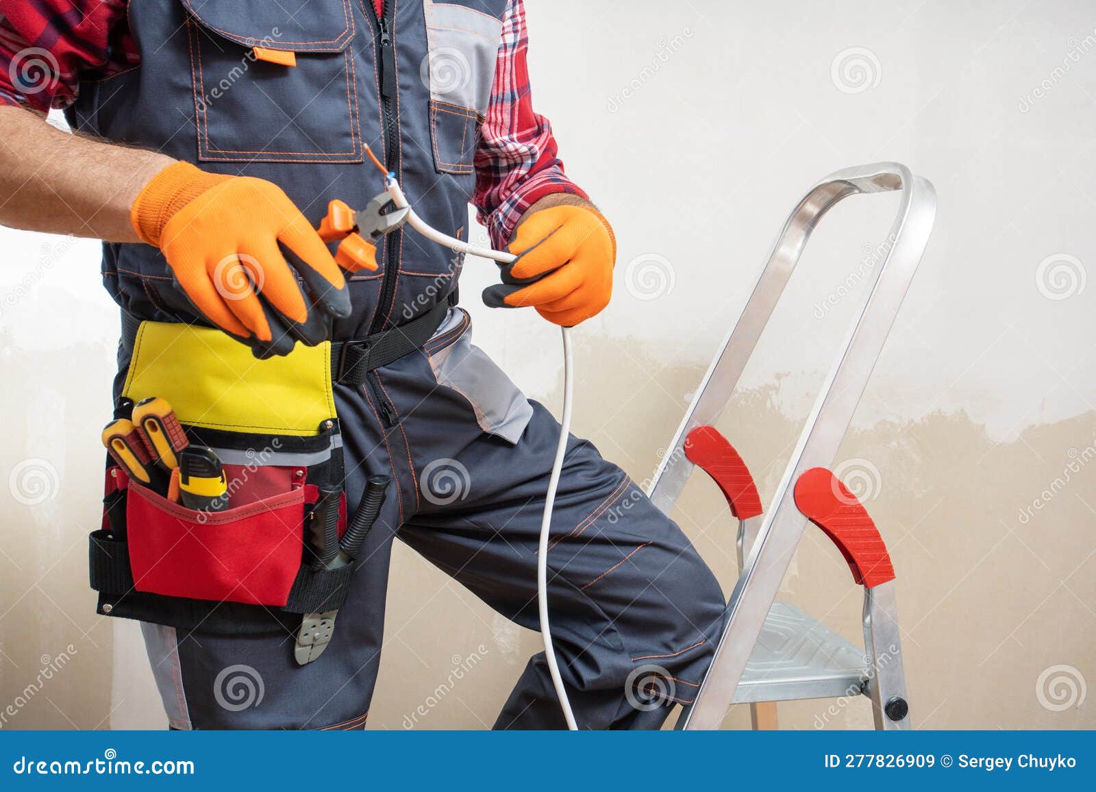 Electrician at Work with Nippers in Hand Cut the Electric Cable