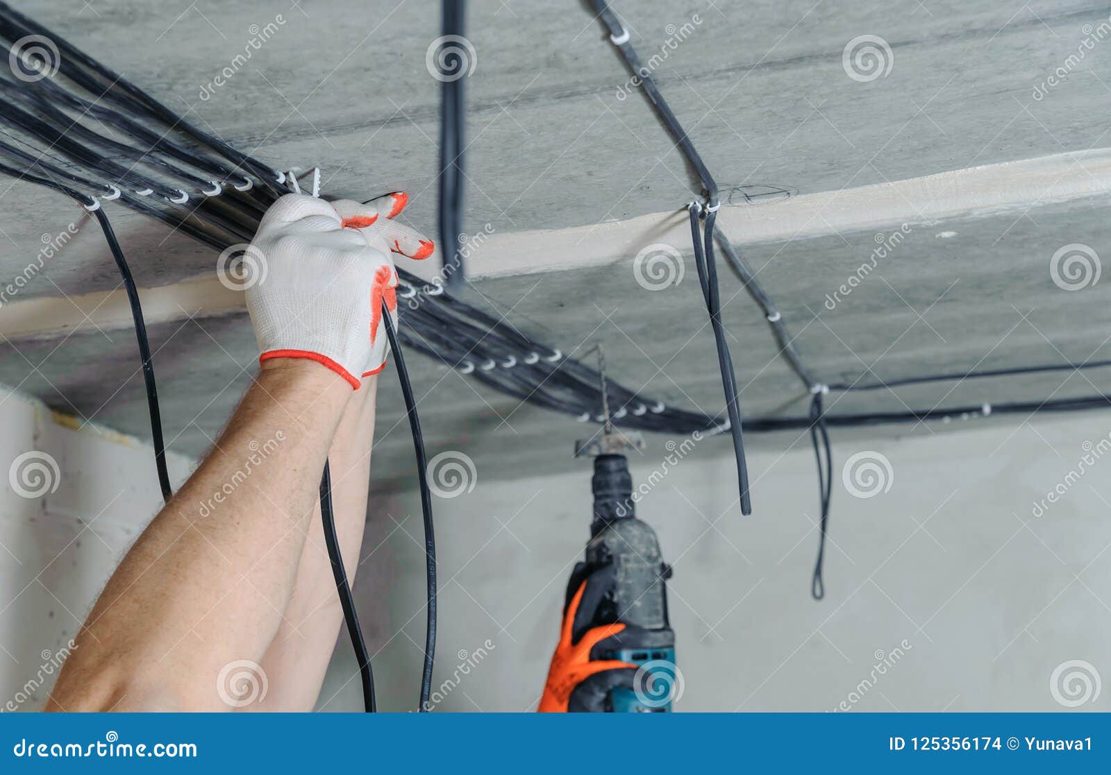 Electricians Are Fixing Electrical Cables To The Ceiling