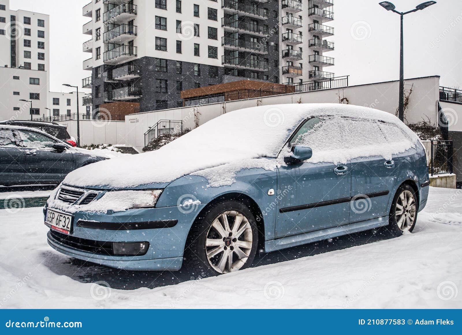Classic Blue Car Saab Aero Covered with Snow during Snowfall in Harsh