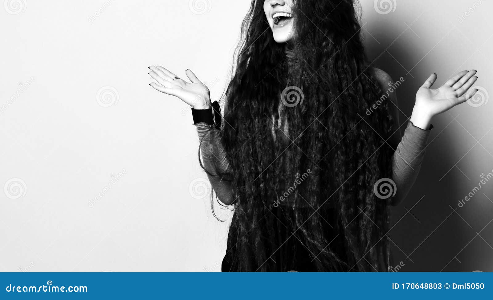 female with long hair in brown turtleneck, short skirt, nylon tights. laughing, gesticulating posing on beige background. close up