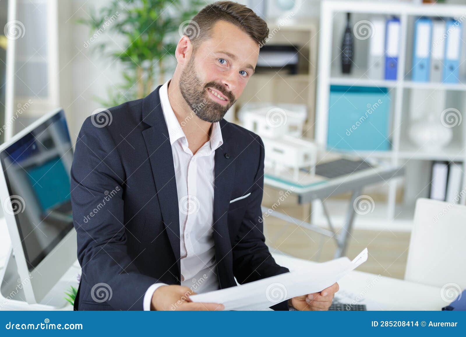 Elegant Man Sitting at Desk in Contemporary Office Stock Photo - Image
