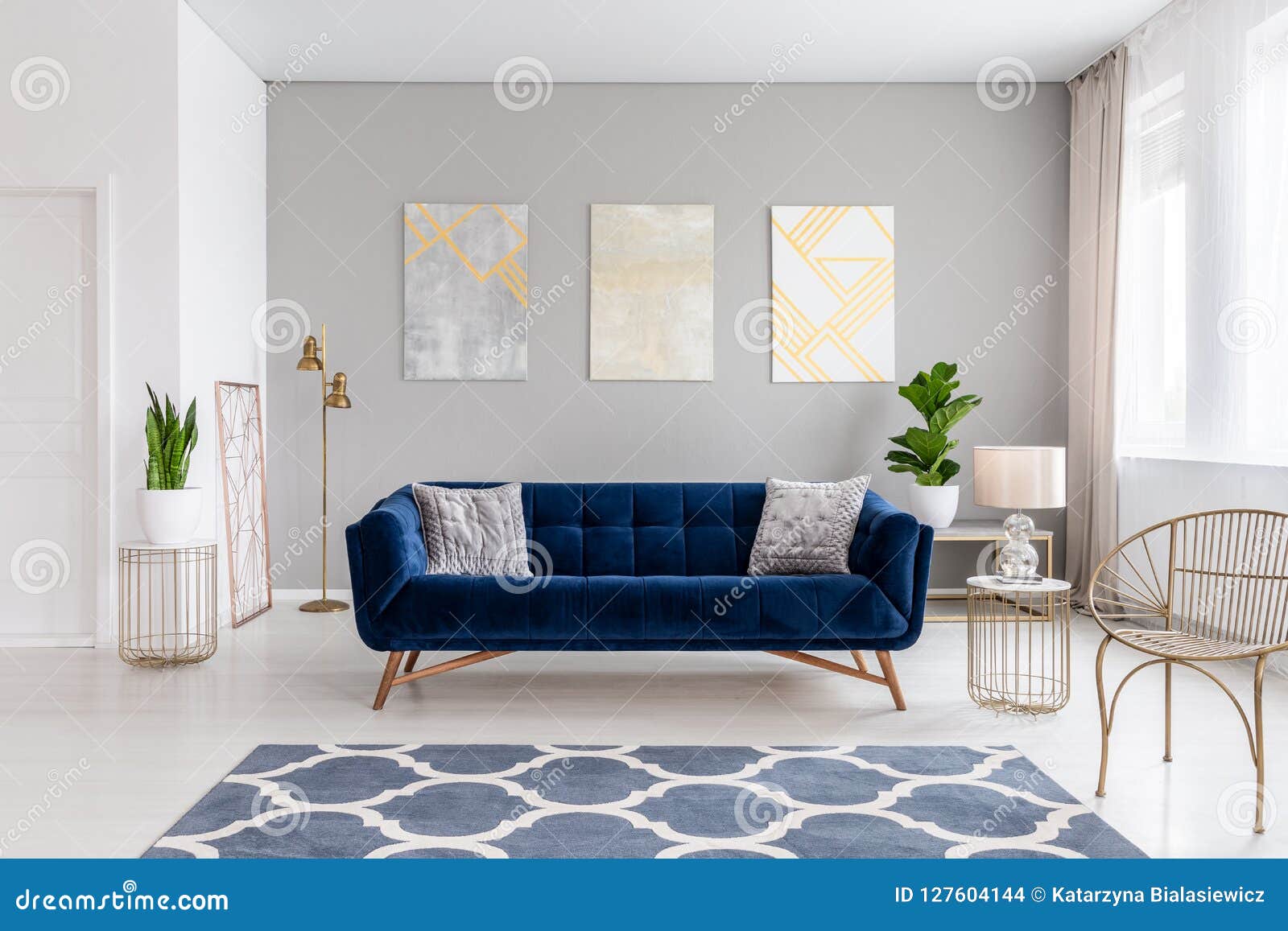 An Elegant Navy Blue Sofa In The Middle Of A Bright Living Room