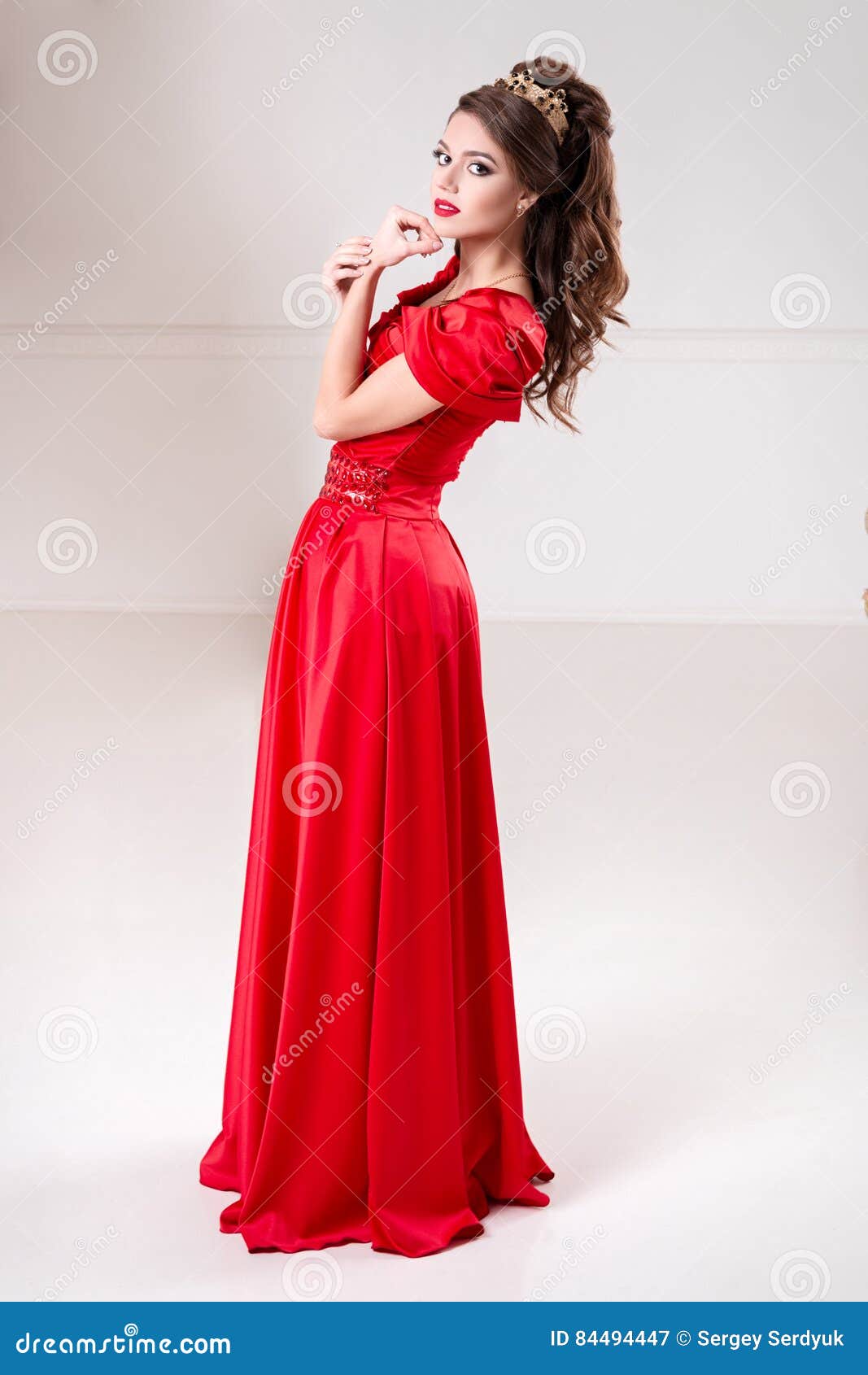 Elegant Woman in a Long Red Dress is Standing in a White Room Stock ...