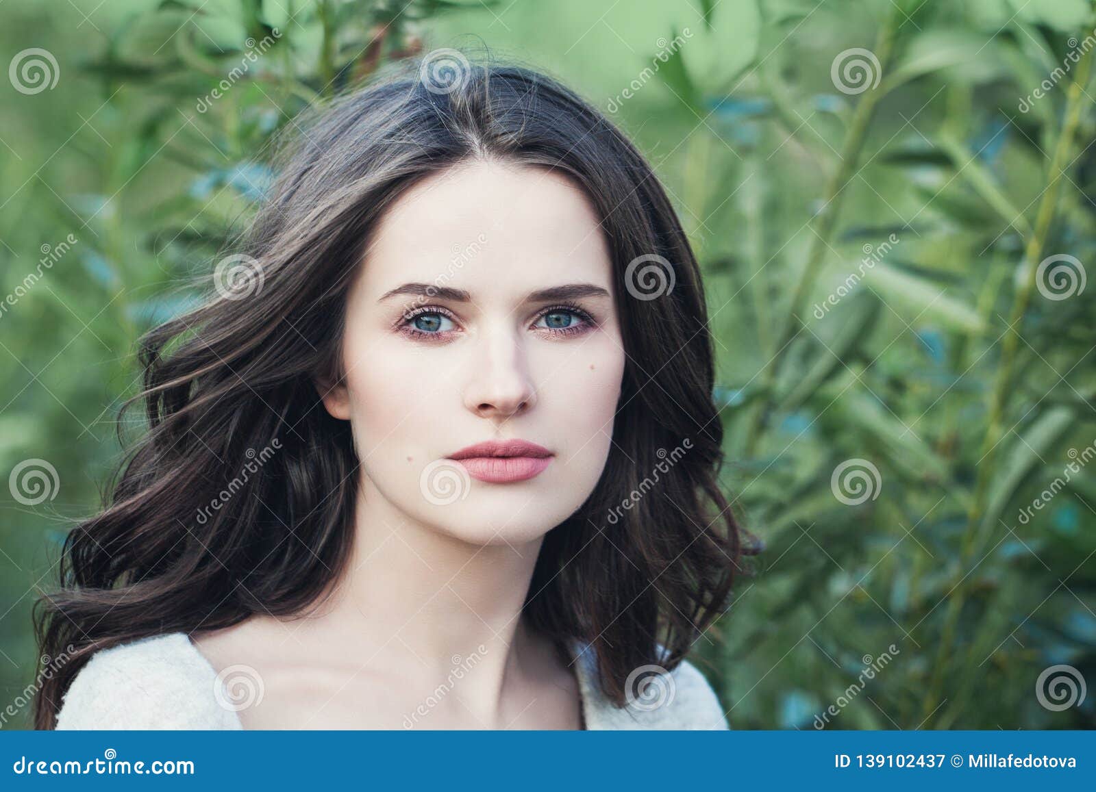 elegant woman outdoor. pretty brunette girl face on green spring background, natural beauty