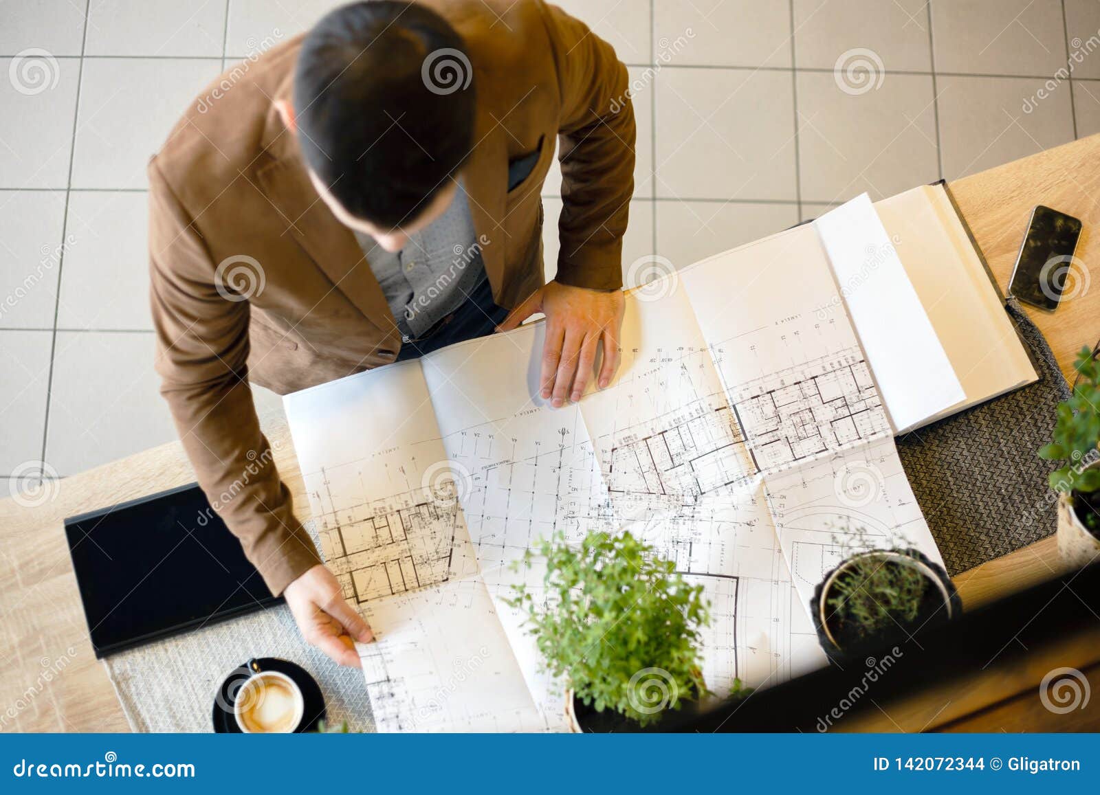 Young Architect Looking At Building Floor Plans High Angle View