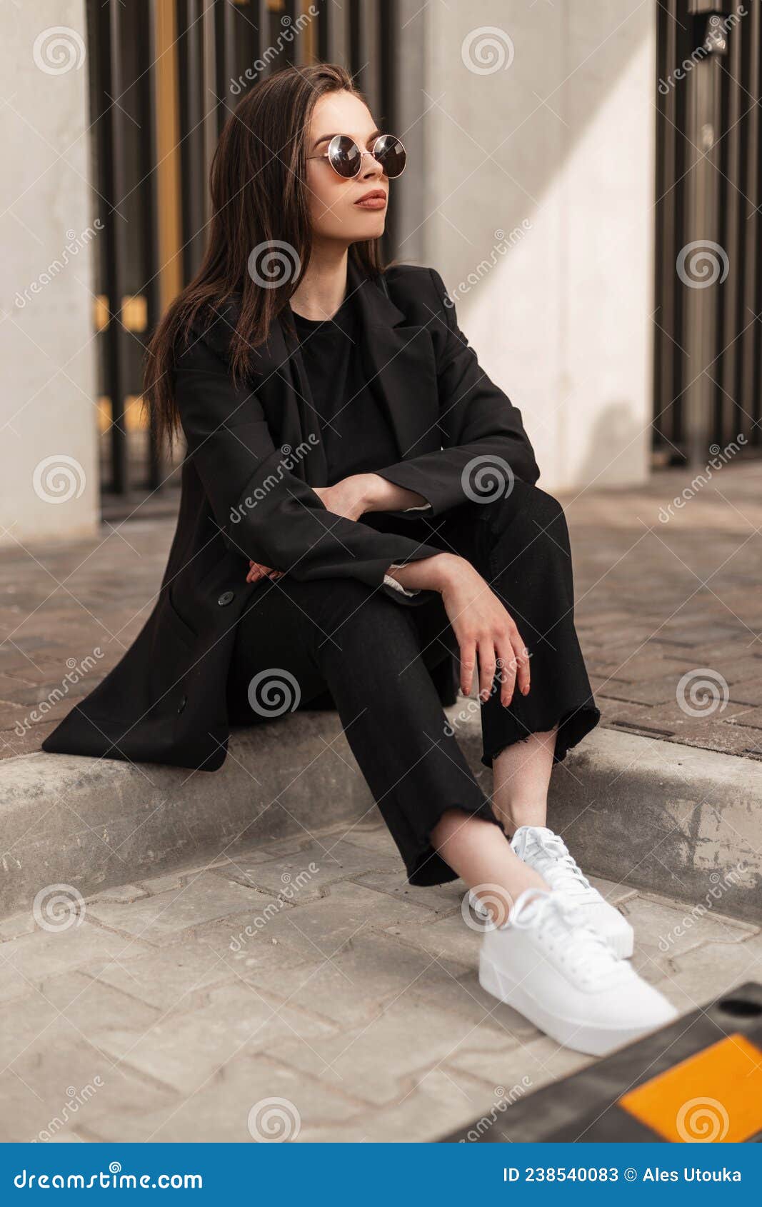 Elegante Jovencita Linda Con Ropa De Calle Negra De Moda Con Pantalones a  La Vista Y Zapatillas Blancas Sentadas En La Calle Imagen de archivo -  Imagen de ciudad, lifestyle: 238540083