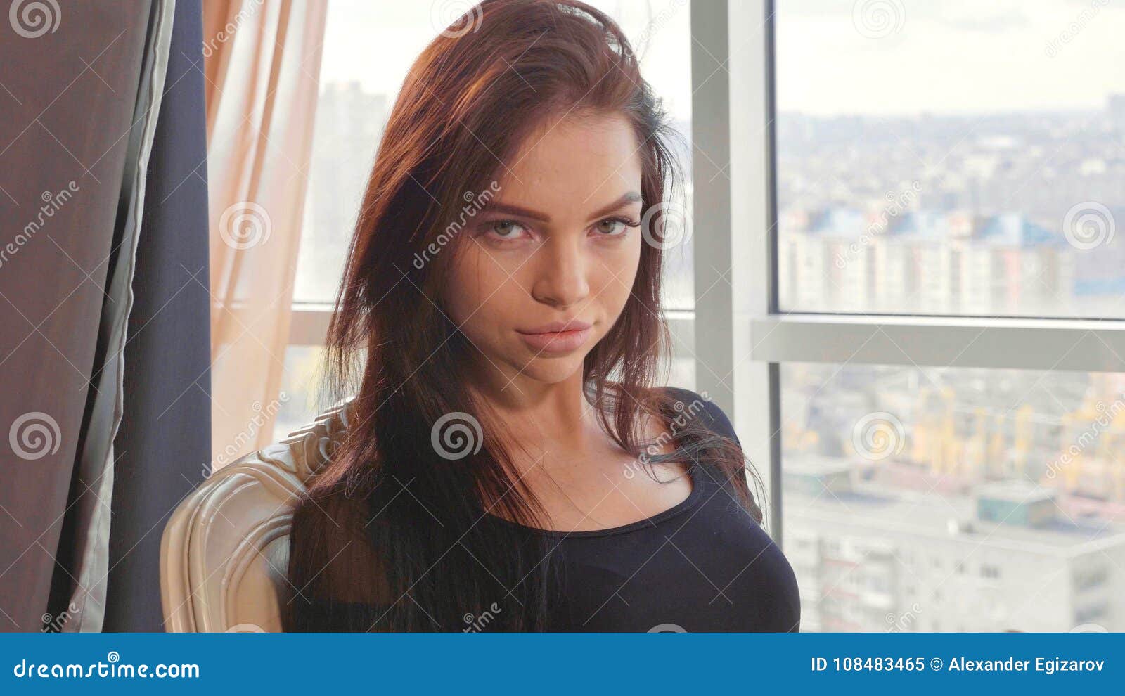 Elegante Junge Frau Im Schwarzen Kleid, Das Auf Stuhl Nahe