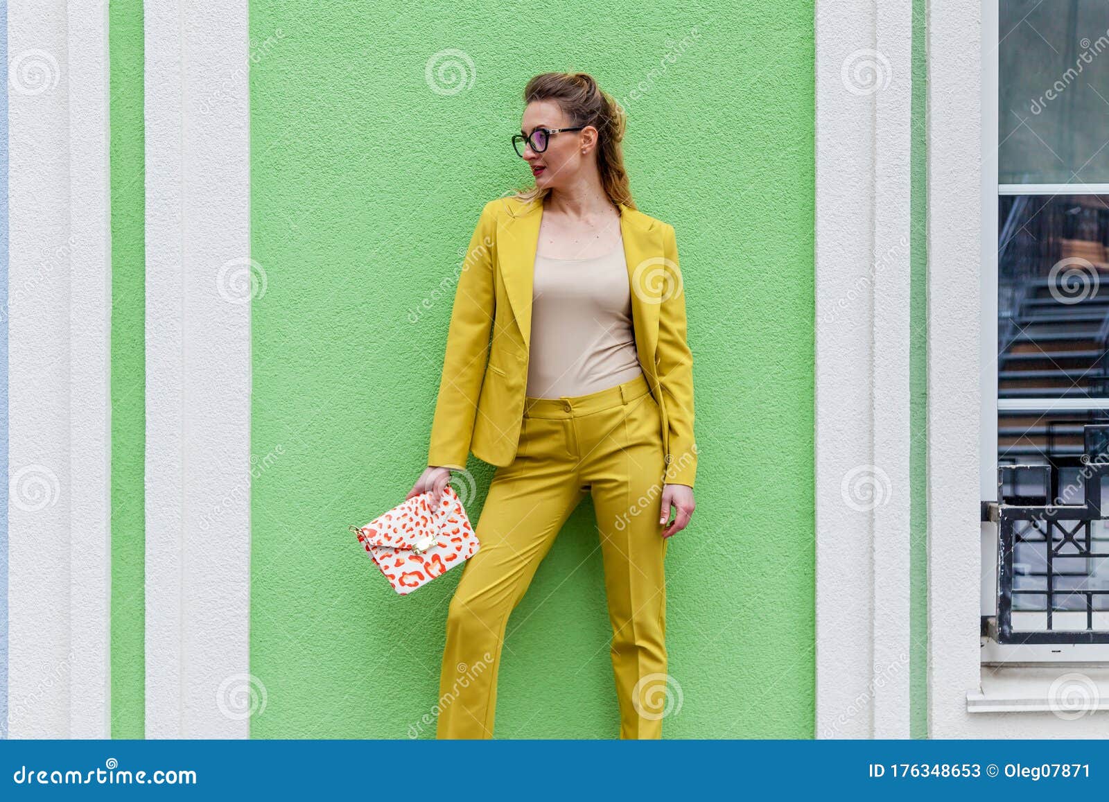 Kiezelsteen magnifiek Makkelijk te lezen Elegante Vrouw Met Een Geel Pak Op De Achtergrond Van Een Groene Muur Stock  Afbeelding - Image of status, kleren: 176348653