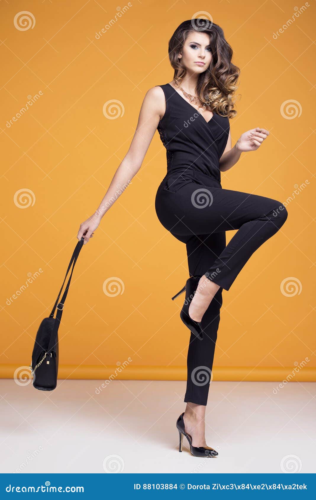 Elegantly Dressed Woman Posing on a Yellow Background Stock Photo