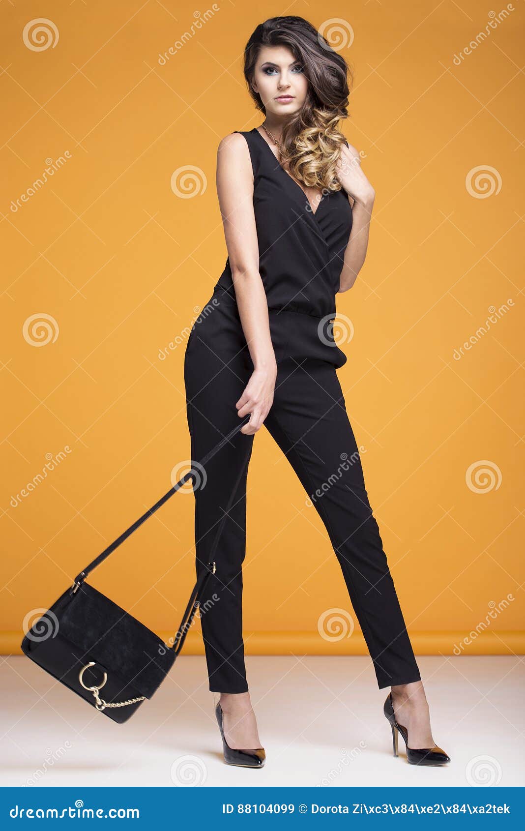 Elegantly Dressed Woman Posing on a Yellow Background Stock Image