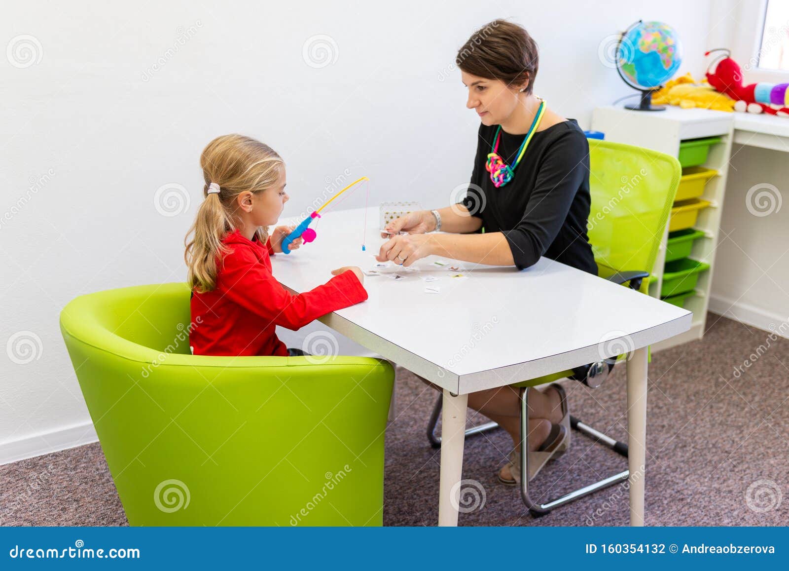 ary age girl in child occupational therapy session doing playful exercises with her therapist.