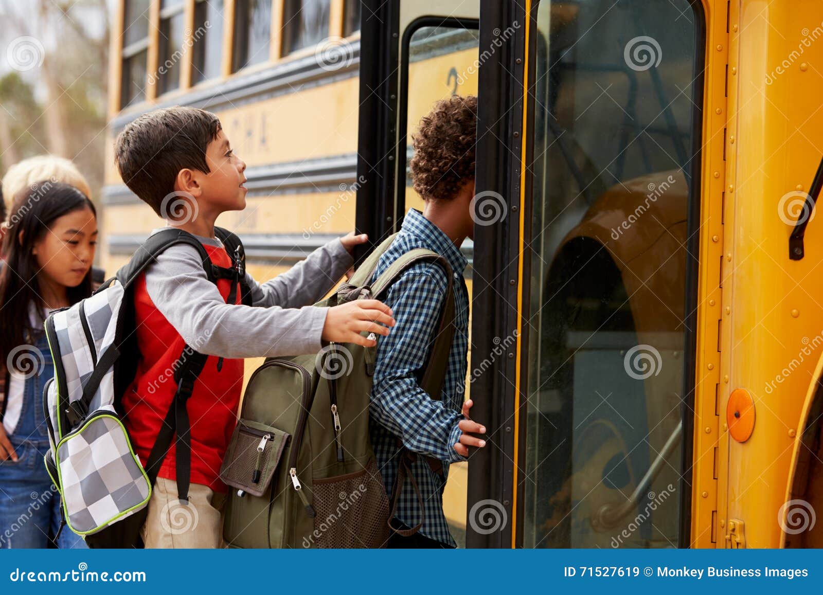 ary school kids climbing on to a school bus