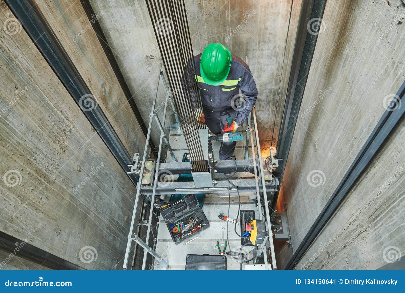 lift machinist repairing elevator in lift shaft