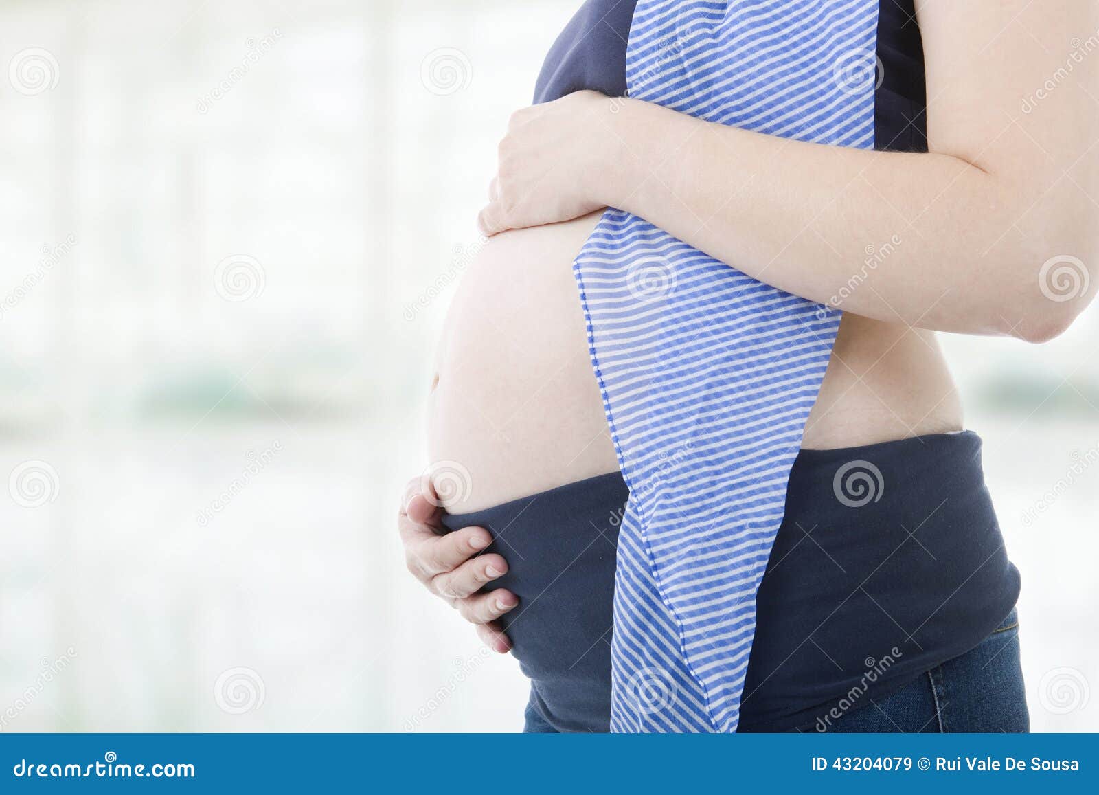 Primer de la mujer embarazada en el fondo blanco
