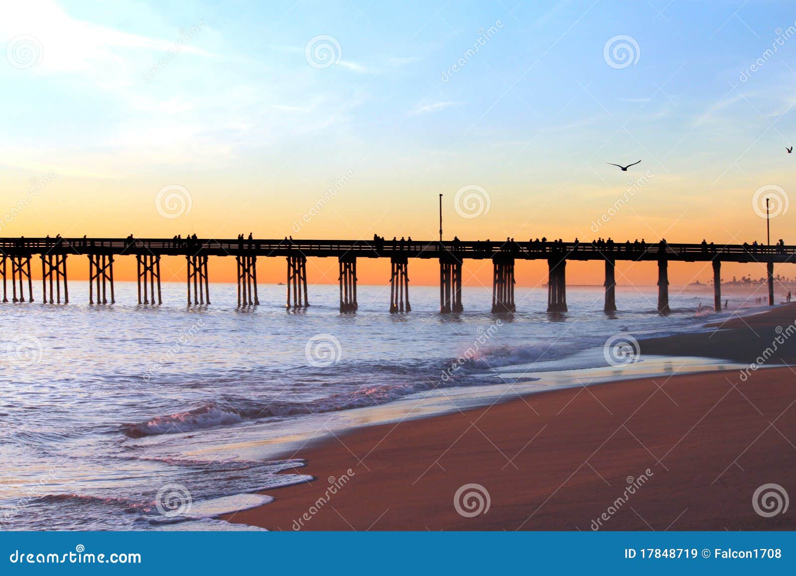 El sol que comienza a fijar en el embarcadero del balboa en la playa de Newport en California