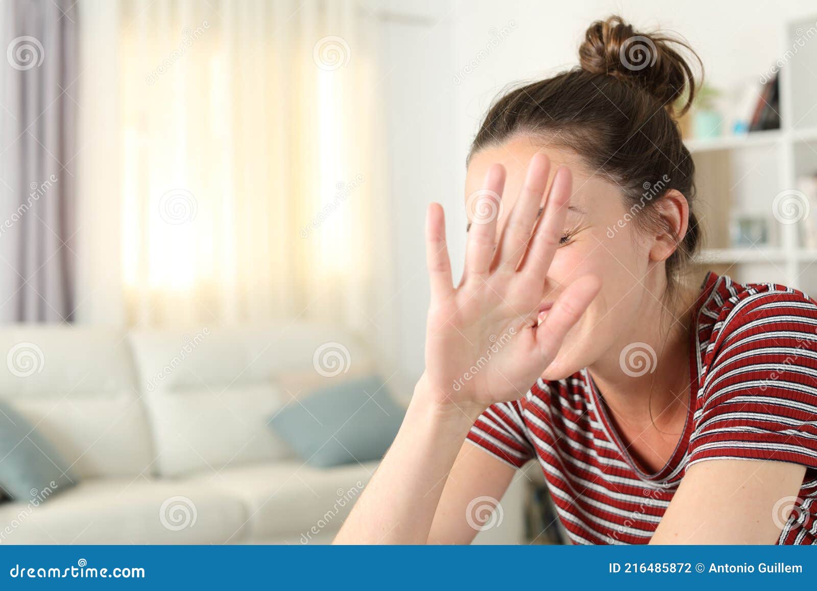 embarrassed woman avoiding photo shoot at home