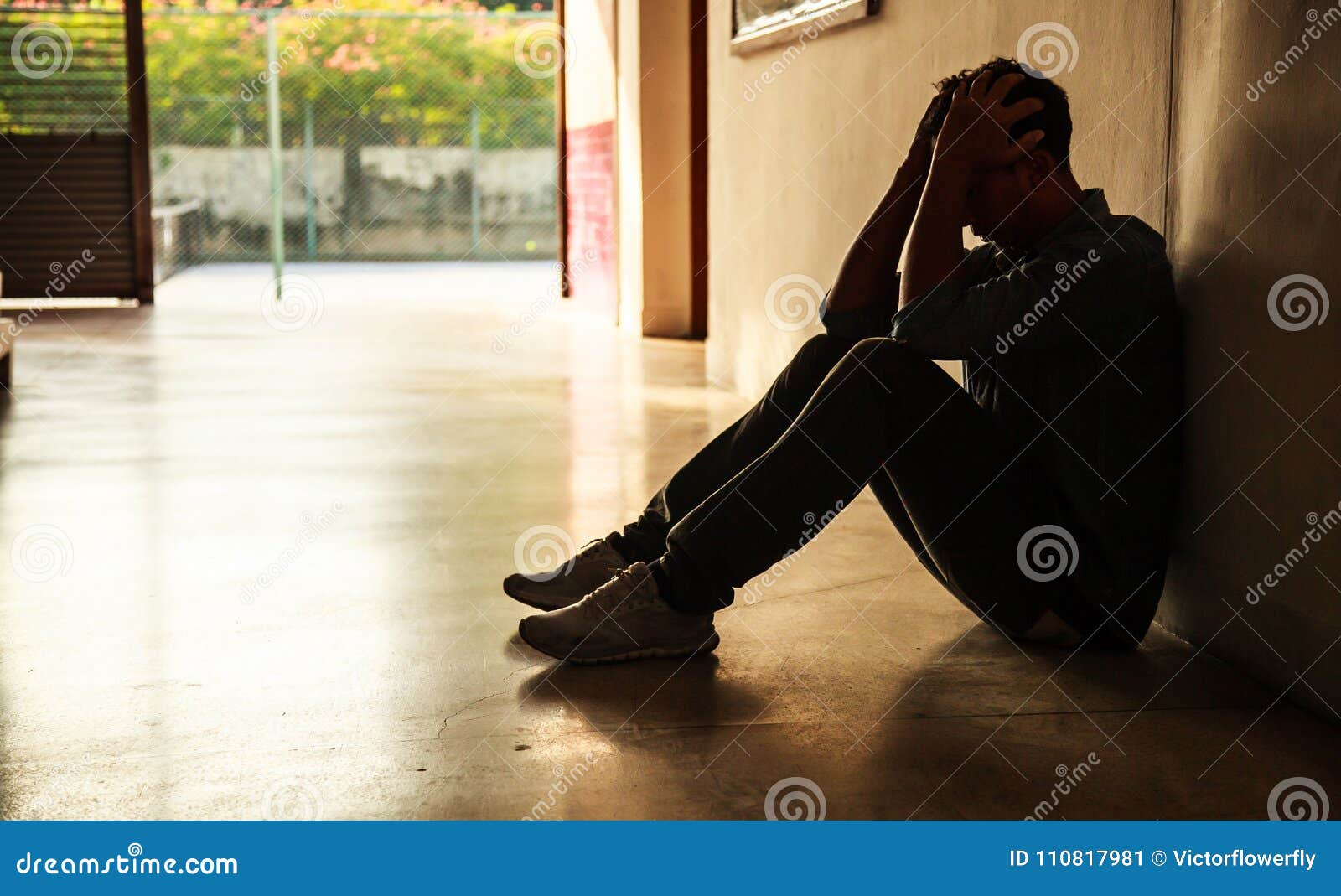 emotional moment: man sitting holding head in hands, stressed sad young male having mental problems, feeling bad, depressed