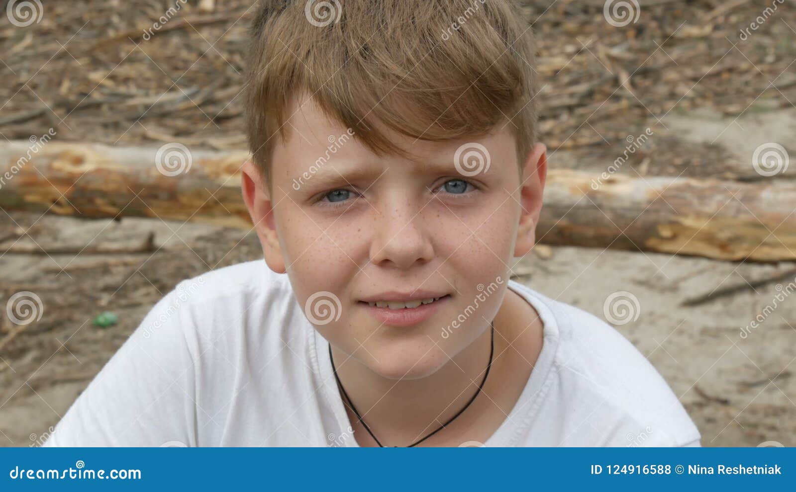 Emotional Portrait Of Red Haired Teenager Boy With Blue Eyes And Freckles That Looks Into The Camera Greenery Backpack