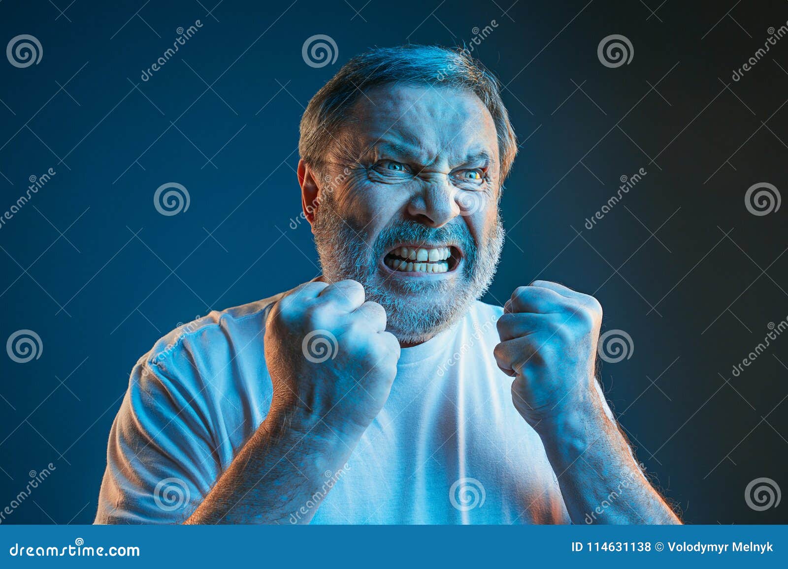 the senior emotional angry man screaming on blue studio background