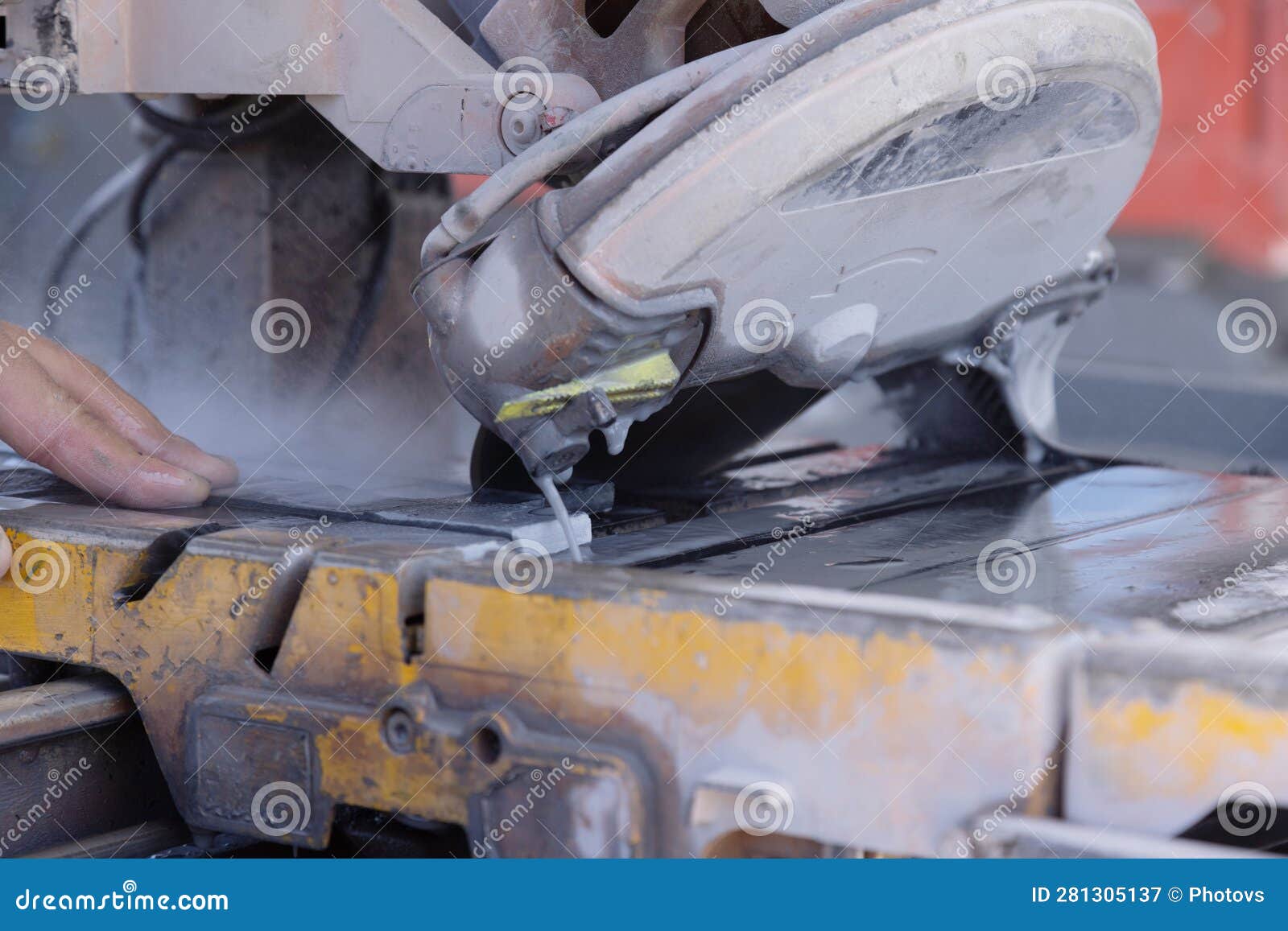 An Employee Cuts Ceramic Tile on a Wet Saw with a Diamond Blade Stock