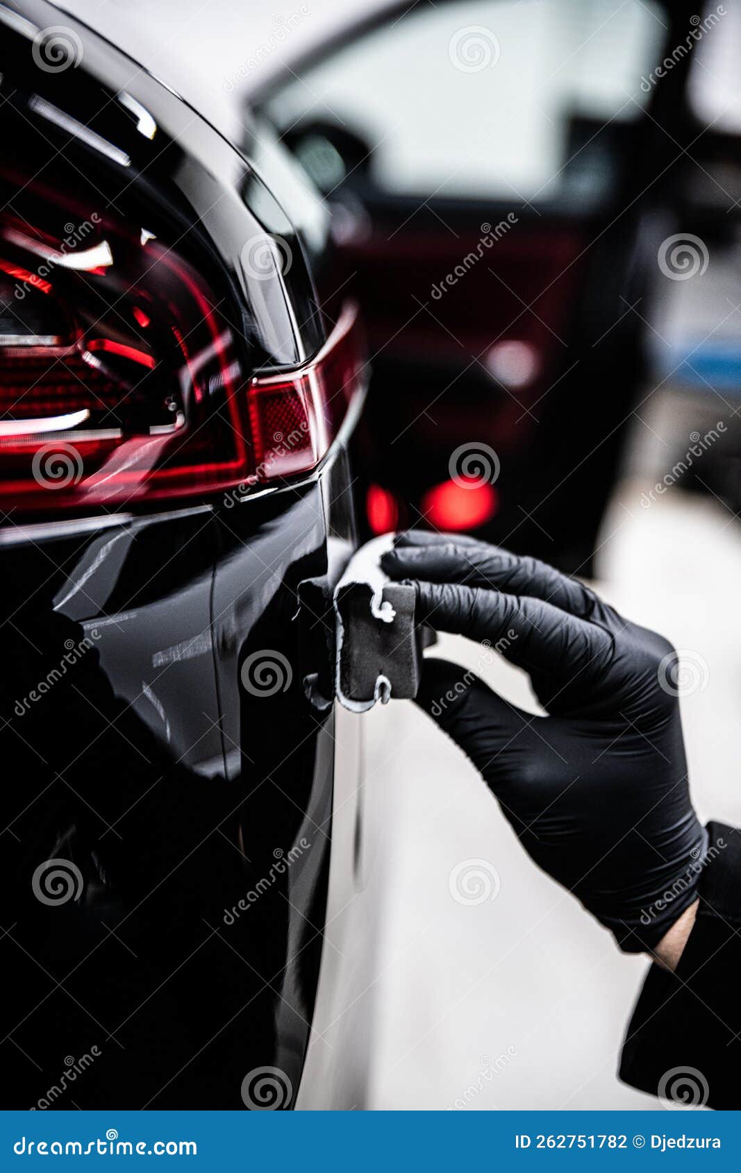 employee of a detailing studio or a car wash applies a ceramic or graphene coating