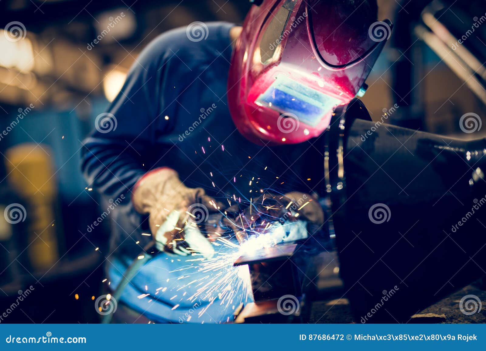 employee welding steel with sparks using mig mag welder