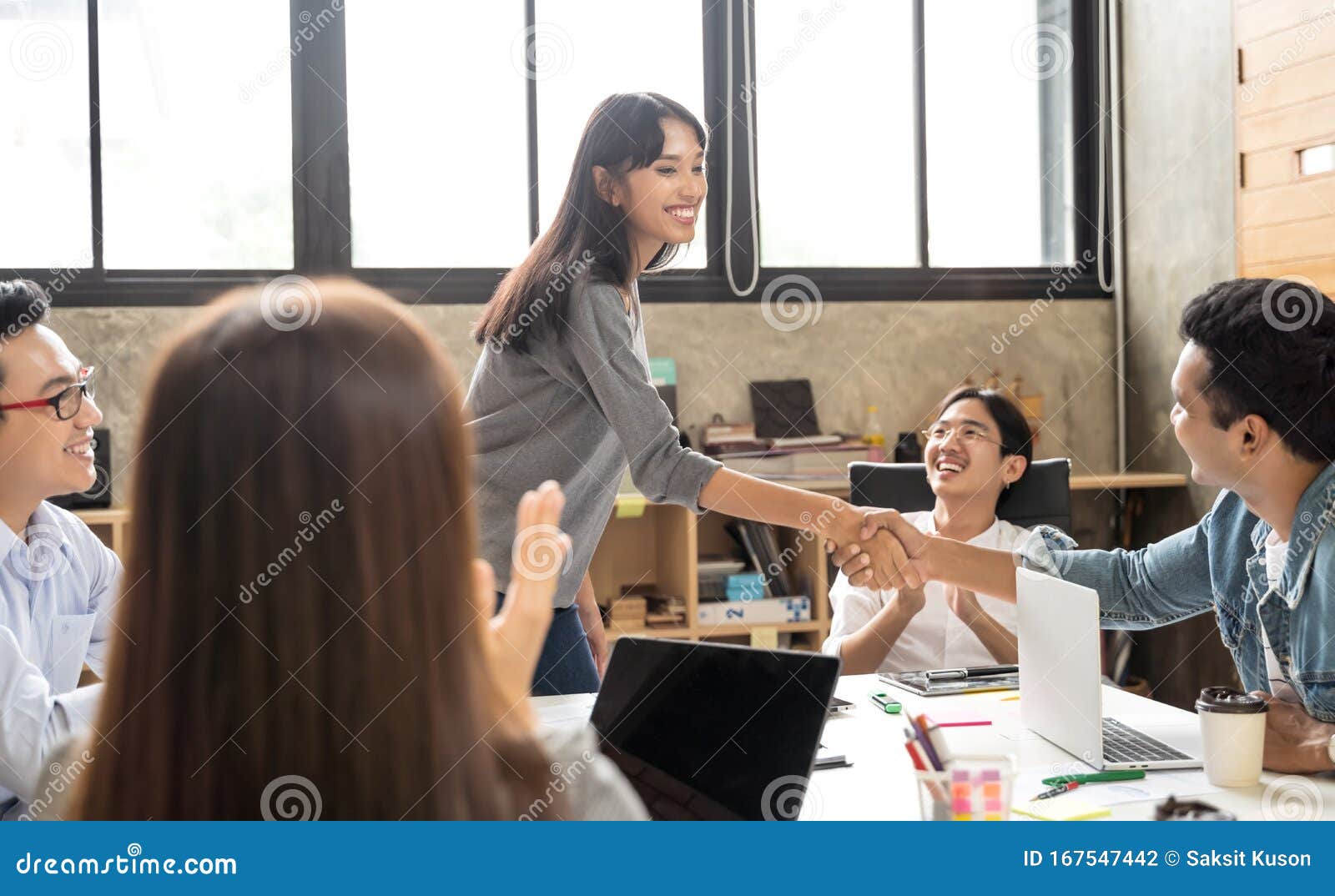 Empresários asiáticos desgastam casuais inteligentes apertando as mãos enquanto trabalham no escritório criativo Conceito de criação de equipes de negócios