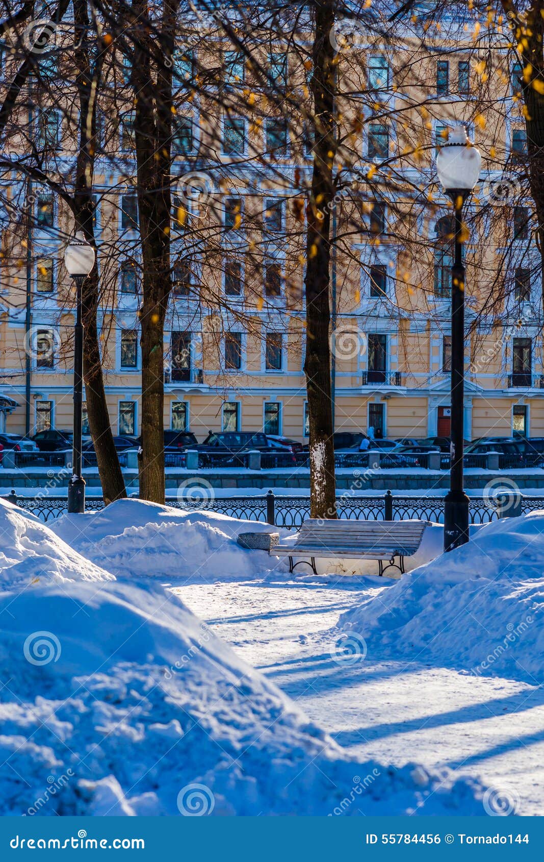 Empty Bench In A Small Snow Covered Street Garden Stock Photo