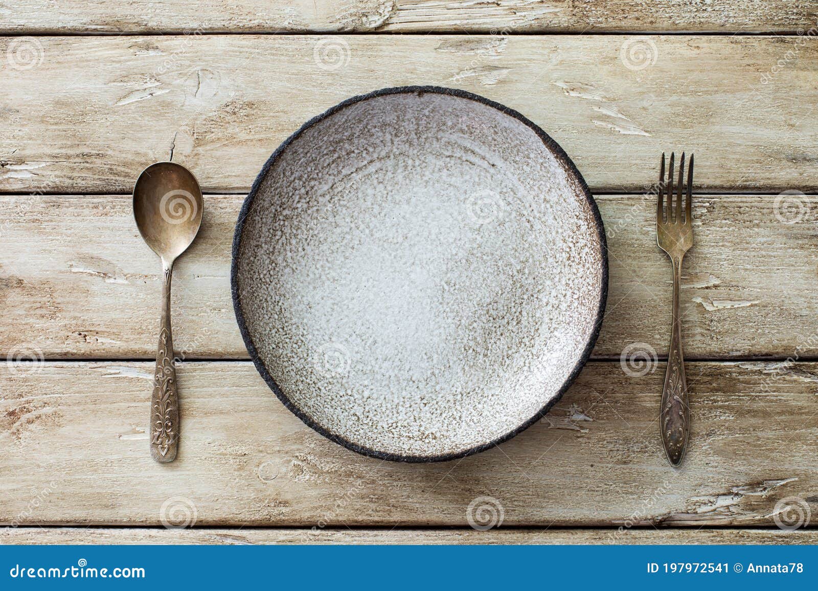 Empty Ceramic Plate, Vintage Spoon and Fork on Old Wooden Background
