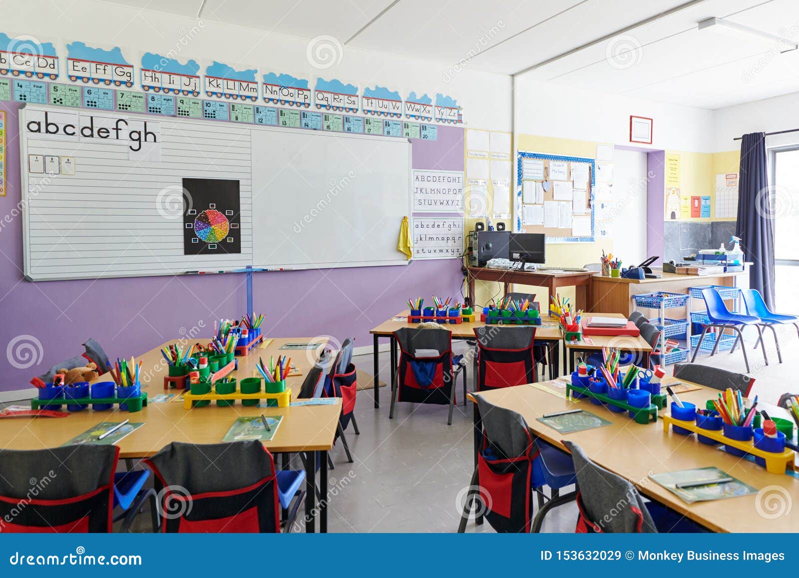 empty classroom in ary school with whiteboard and desks